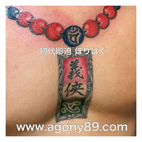 数珠から胸元に、千社札の様な彫刻プレーに漢字の刺青