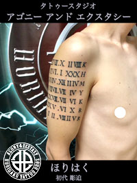 二の腕にローマ数字とイニシャルのタトゥー画像【エゴニー アンド エクスタシー タトゥーデザインスタジオ】彫迫