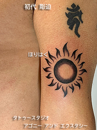 腕にブラック＆グレイの太陽のタトゥー画像【エゴニー アンド エクスタシー タトゥーデザインスタジオ】彫迫