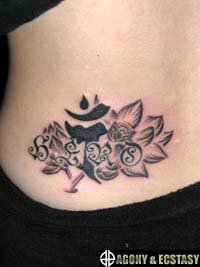 女性の腰に蓮と梵字のタトゥー